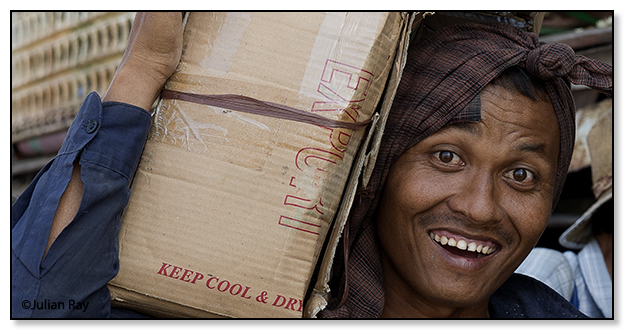Worker carrying a load with a big smile